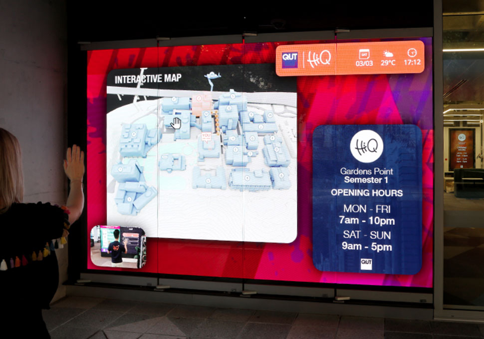 Graphic design, student interacting with map on large LED screen at HiQ Gardens Point QUT using Kinect cameras, with digital content by Maya Walker