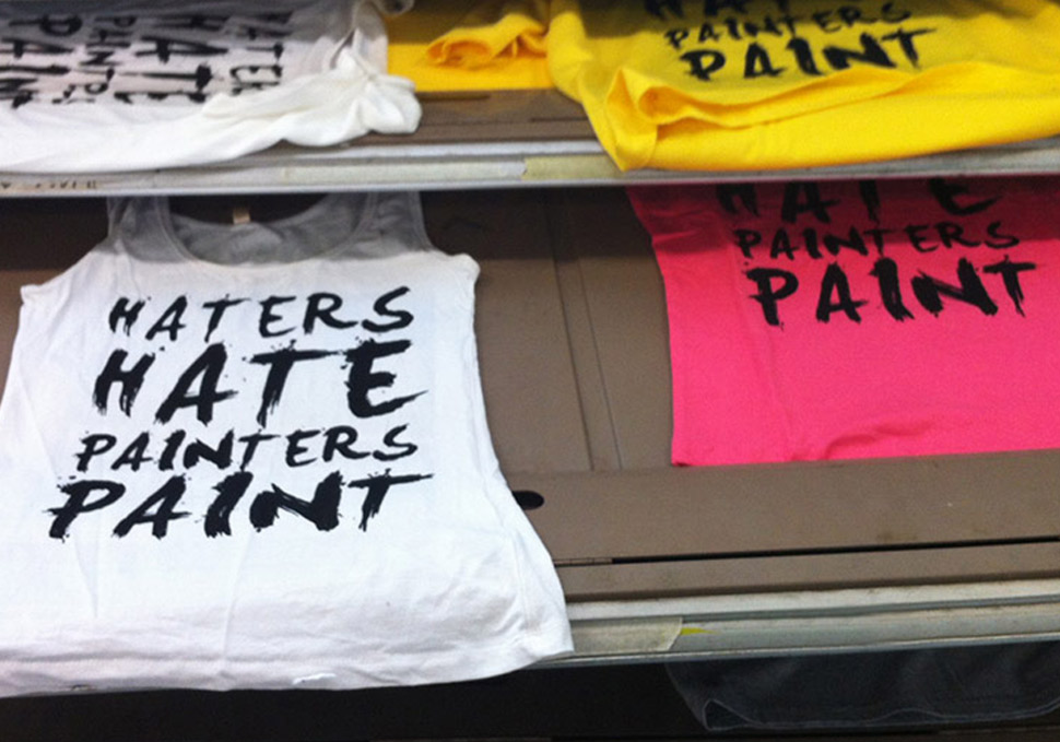Graphic design, several shirts in drying rack with screenprinting 'haters hate painters paint' by Maya Walker
